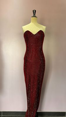 robe rouge à paillettes sur un mannequin devant un mur