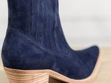 a close up of a pair of blue sued boots on a wooden table