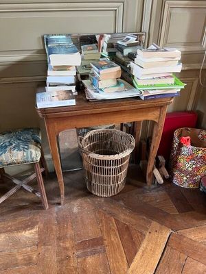 une petite table sur laquelle se trouve un panier rempli de livres