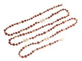 a close up of a long beaded necklace on a white background