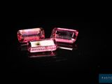deux cubes de cristal rose posés sur une surface noire