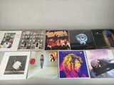 various albums and cds are arranged on a white table