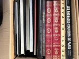 une boîte pleine de livres posée sur le sol