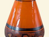 un vase orange posé sur une table