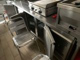 une cuisine équipée d'une cuisinière, d'un four et de chaises