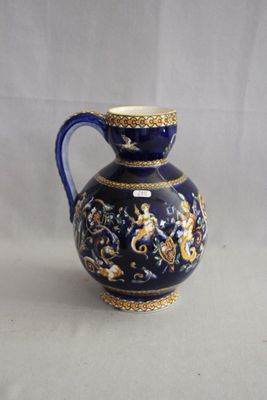 un vase bleu et or posé sur une surface blanche