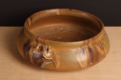 un bol marron posé sur une table en bois