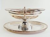 a silver plate with a bird on top of it