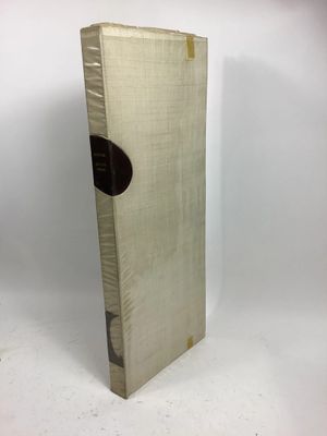 an old book sitting on top of a white table next to a white wall