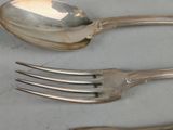 two forks and a spoon sitting on a table