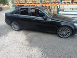 a black car parked in front of a warehouse filled with pallets