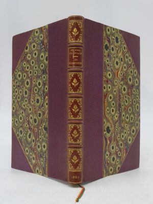 un vieux livre à la couverture rouge et aux bords dorés sur fond blanc