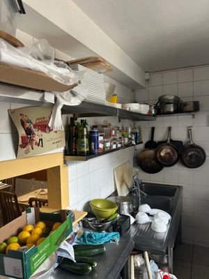 a small kitchen with a lot of clutter on the counter