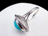 an image of a ring with a turquoise stone on a white plate