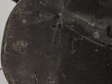a close up of a metal object on a wooden surface