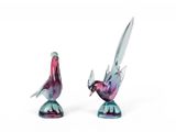 paire de figurines d'oiseaux en verre colorées posées sur un socle, sur fond blanc