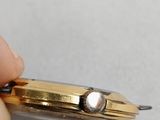 someone holding a watch in their right hand with a diamond on it