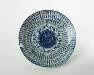 une assiette bleue et blanche ornée d'un motif