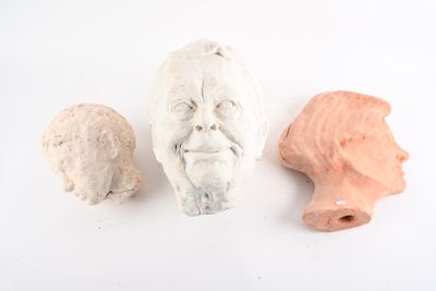 trois sculptures en argile représentant le visage d'un homme et la tête d'une femme