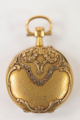 an image of a gold pocket watch with a bird on it