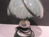a green and white lamp that is on a white table