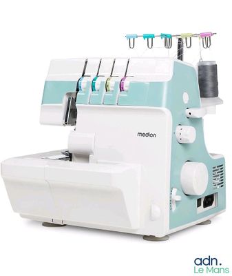 une machine à coudre posée sur une surface blanche