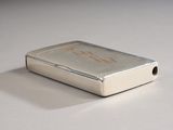 a silver lighter sitting on a white surface