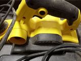 a yellow corded sander sitting on top of a tool box