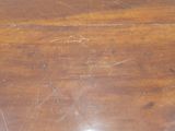 a close up of a wooden table with scratches on it