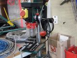 une perceuse posée sur un établi sur lequel sont disposés des outils