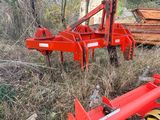 a red plow that is sitting in the grass