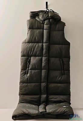 une photo d'une veste matelassée noire accrochée à un mur