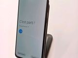 a close up of a cell phone on a stand on a white surface
