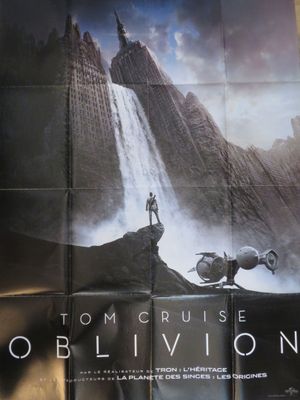 une image d'une affiche du film « Oblivion » représentant un homme debout au sommet d'une montagne
