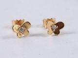 a close up of a pair of gold and diamond earrings