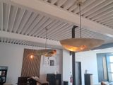 two lamps hanging from the ceiling above a dining room table