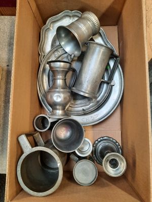 une boîte remplie d'objets en argent posée par terre