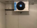 un ventilateur dans un coin d'une pièce équipée d'un ventilateur de plafond