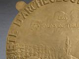 an image of a close up of a gold medal on a black surface