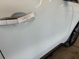a white car with a sticker on it ' s door handle