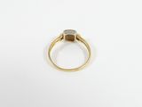 a close up of a gold ring with a diamond on it