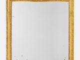 un miroir encadré d'or sur un mur blanc avec un fond blanc