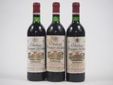 trois bouteilles de vin rouge posées l'une à côté de l'autre sur une surface blanche