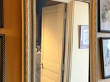 un miroir accroché au mur à côté d'un lavabo