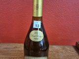 La bouteille de vin est posée sur une table en bois devant un mur rouge.