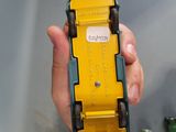 a person holding a yellow toy car in their hand