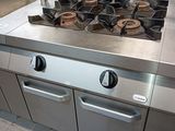 stainless steel counter top in a commercial kitchen with a stove and oven