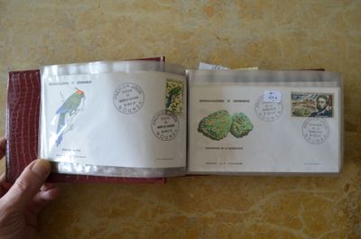 une personne tenant un livre ouvert sur lequel figurent des timbres