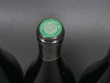 three bottles of wine are lined up on a black surface