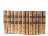 six old books lined up in rows on a white surface